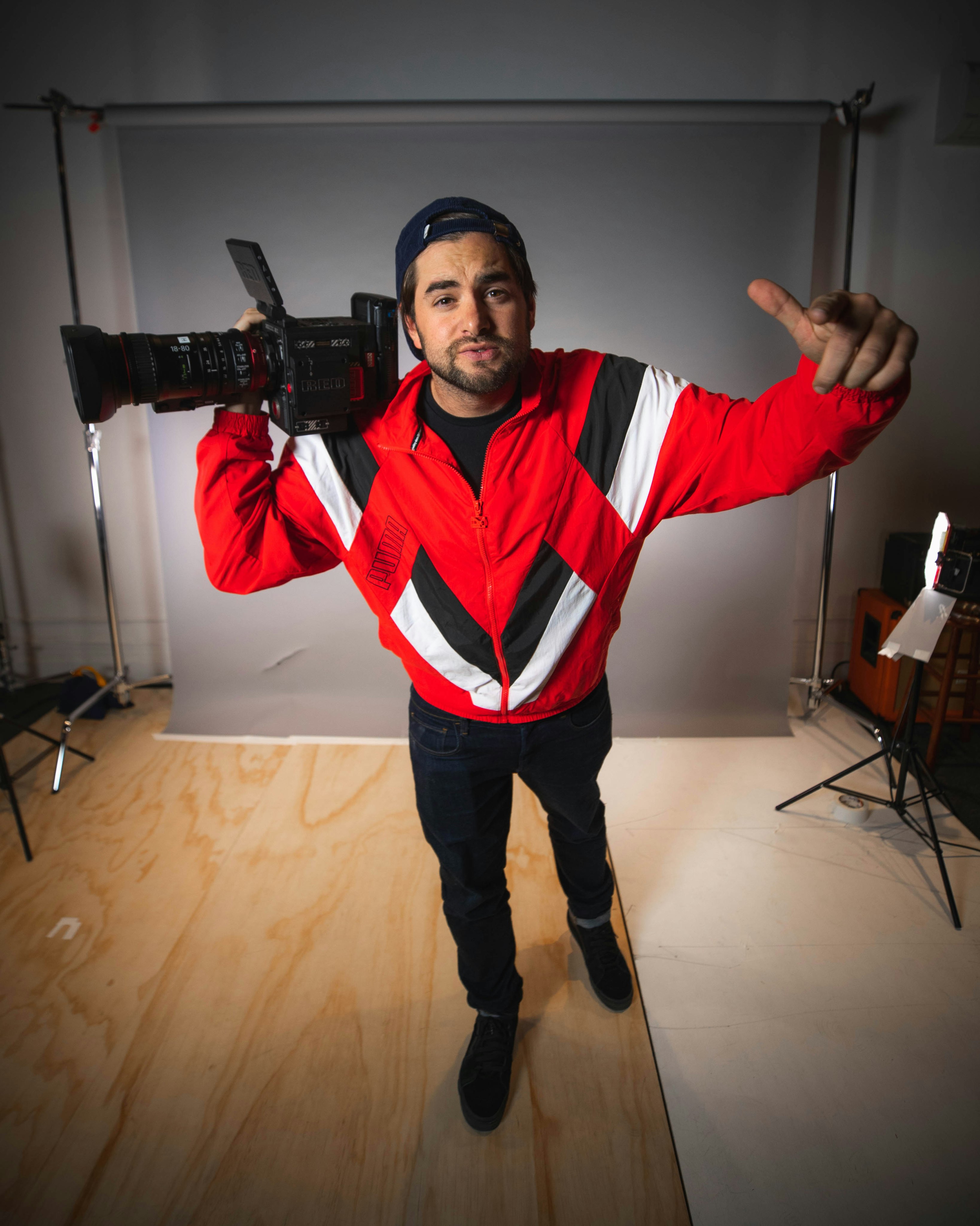 A content creator with long hair focuses on his camera, capturing the scenic beauty of an outdoor landscape, perfect for stock footage